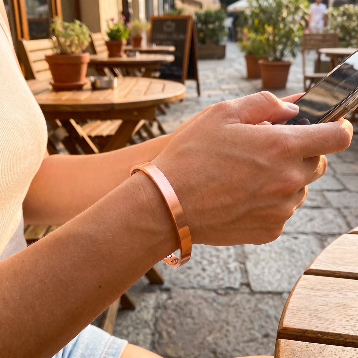Woman wearing the Quantum copper magnetic bracelet while using a phone