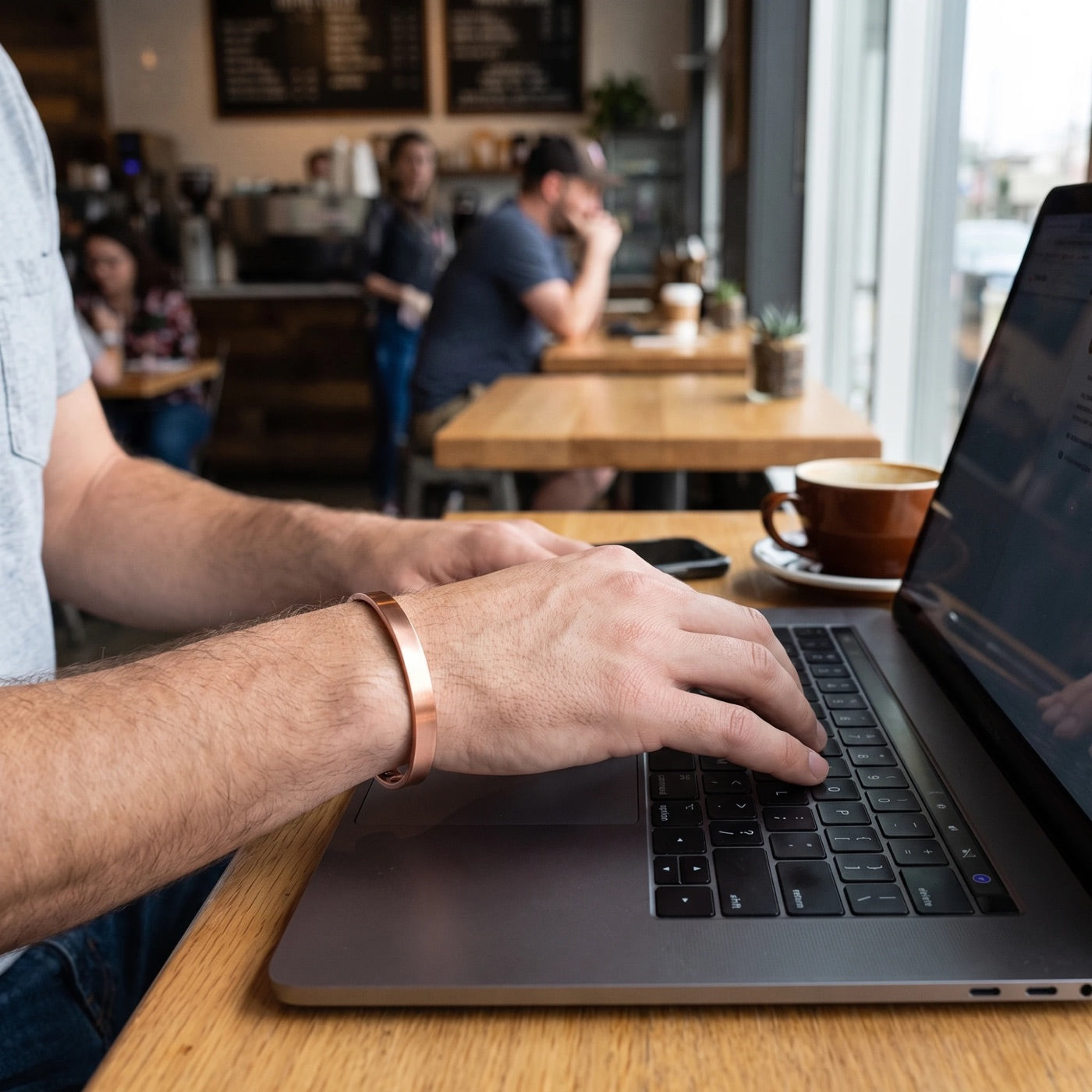 Man wearing the Quantum copper magnetic bracelet while working at a laptop